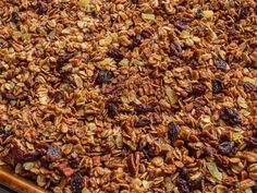 a large wooden tray filled with granola and raisins