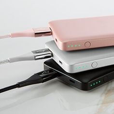 three different types of electronic devices are stacked on top of each other, one is pink and the other is silver