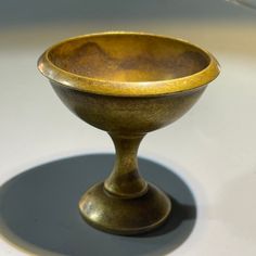 a golden bowl sitting on top of a white table