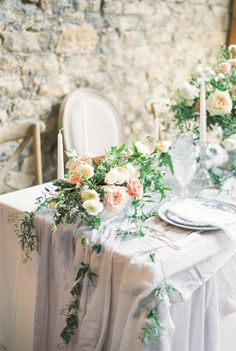 the table is set with flowers and candles