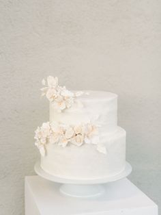 a three tiered white cake with flowers on top