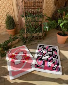 two rugs sitting on the ground next to potted plants