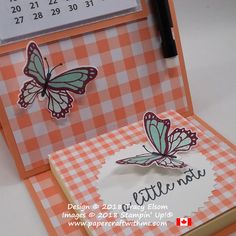 a close up of a card with butterflies on it and a calendar in the background