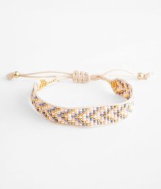 a white bracelet with blue and yellow beads on it's end, sitting against a white background