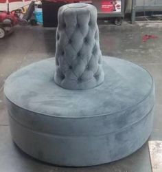 a large round ottoman sitting on top of a cement floor