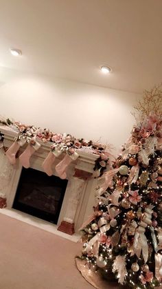 a decorated christmas tree in front of a fireplace