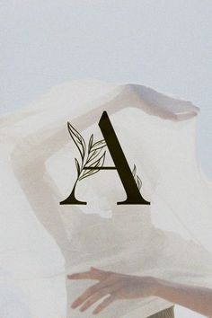 the letter a is made up of leaves and branches on top of a woman's head