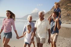 a family walking on the beach holding hands