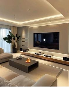 a living room with white couches and a flat screen tv mounted on the wall