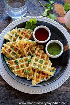 a plate with waffles and dipping sauces on it