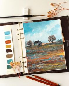 an open notebook with a painting on it