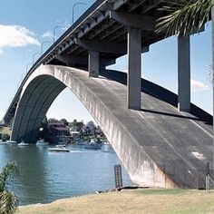 a large bridge spanning over a body of water with palm trees on the other side