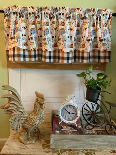 a rooster statue sitting on top of a table next to a clock