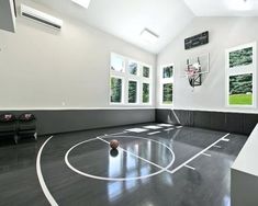 an indoor basketball court is shown in the middle of a room with high ceilings and large windows