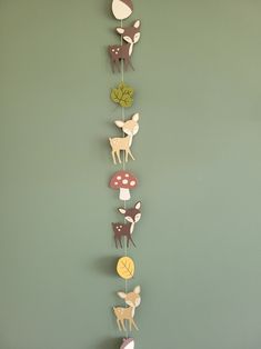 a group of deer and mushrooms hanging from the side of a wall in a green room