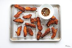 fried chicken sticks on a cooling rack with dipping sauce and seasoning in a bowl