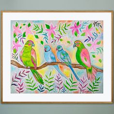 three colorful birds perched on a branch with leaves and flowers in the background, framed art print