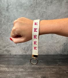 a woman's arm with a white wristband that has pink arrows on it