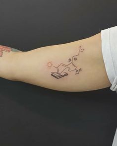 a woman's arm with a book and stars tattoo on the left side of her arm