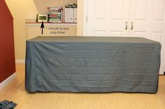 the table is covered with a gray cloth and has an arrow pointing to the left