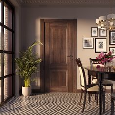 a dining room table and chairs with pictures on the wall above it, next to a potted plant