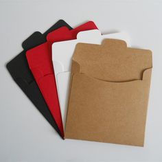 four folders are lined up next to each other on a white surface, one is open and the other has a brown envelope