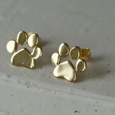 Please allow 10-15 days for production and delivery if item is not in stock.  Description:  Show your love and appreciation for dogs with these paw stud earrings; each earring features an intricately detailed, realistic paw design. Perfect for everyday wear and special occasions. Details:  Materials: Gold Vermeil (Rose or Yellow) or Sterling Silver Paw Dimensions: 1cm Stud Gold Earrings, Paw Design, Dog Paw, Magpie, Dog Paws, Sterling Silver Earrings Studs, For Dogs, Gold Vermeil, Sterling Silver Earrings