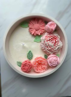 a bowl filled with flowers on top of a table