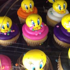 there are many cupcakes with yellow and pink frosting in the shape of ducks