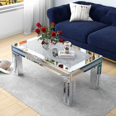 a living room with blue couches and a glass coffee table in the middle of it