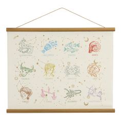 a wooden frame hanging on the wall with zodiac signs and stars painted on it's side