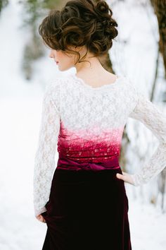 a woman standing in the snow with her hands on her hips wearing a white and red top