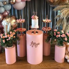 a table topped with pink cakes and cupcakes