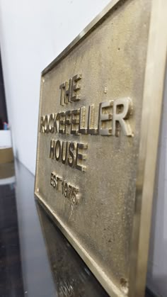 the rockefeller house sign is on display in front of a white wall and black table