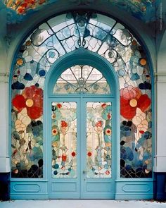 a blue door with stained glass and flowers on it