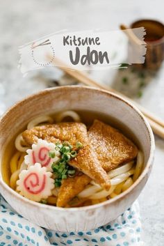 a bowl filled with noodles and fish on top of a table