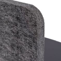 a close up view of the corner of a wall made out of gray carpeting