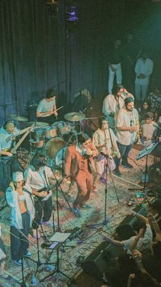 a group of people standing on top of a stage next to each other in front of microphones