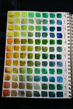 an open notebook with watercolor swatches on it