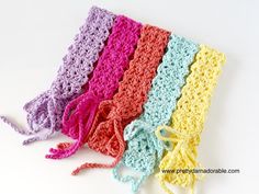 four crocheted pieces of cloth on a white surface