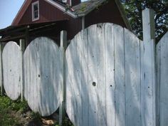 a wooden fence with two circular doors in front of a house