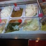 a display case filled with lots of different types of ice cream and toppings on top of each other