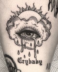 a tattoo with an eye and clouds on it