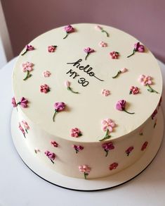 a white cake decorated with pink flowers and the words hello my so on it's side