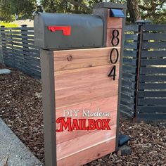 the mailbox is made out of wood and has red lettering on it that says diy modern mailbox