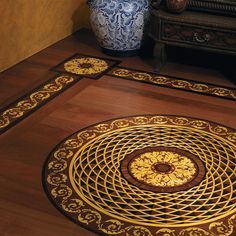 the floor is made up of wood and has intricate designs on it, along with decorative vases