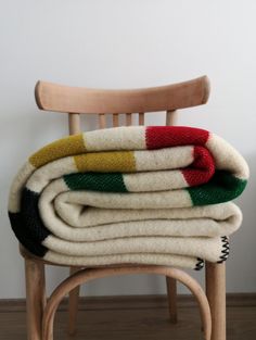 a stack of blankets sitting on top of a wooden chair