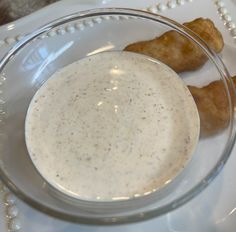 a white plate topped with fried food next to a bowl filled with sauce and dipping sauce