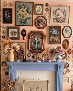 there is a fireplace with many pictures on the wall above it and a vase in front