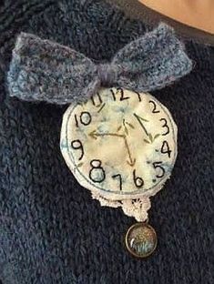 an old clock with a bow on it's neck is attached to a sweater